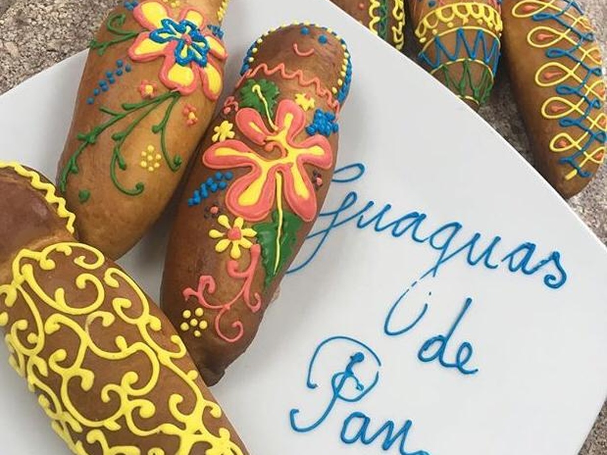 Guaguas de pan decoradas con flores y filigranas de glaseado de colores
